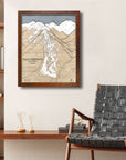 Framed map of Aspen Highlands on a wall above a wooden desk with a chair.