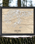 Framed wooden map of Deer Valley Ski Resort in Utah staged on a tree stump with a forest background