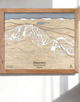 Wooden framed skiing map of Discovery Ski Area on a white wall in a modern ski house.