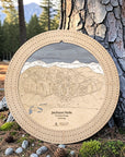 Birch Jackson Hole wooden ski map cribbage board displayed beside a pine tree as a unique gift for skiers.