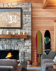 Large framed art print of Pats Peak Ski resort above a mantle in a rustic skiing cabin.