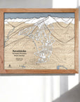 Framed 3D wood map of Revelstoke Ski Resort, British Columbia, on a white wall in a modern ski chalet.