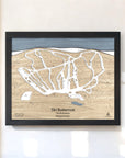 Framed wooden map of Ski Butternut Ski Resort on a white wall in a ski cabin.