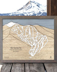 Framed wooden map of Ski Santa Fe with a mountainous background