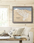 Framed ski trail map of Ski Santa Fe above a sofa in a living room inside a ski cabin.