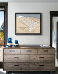 Framed artwork of Ski Santa Fe ski resort on a white wall inside a modern ski house.