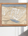 Wooden framed map of Snowshoe Mountain Ski Trails on a white wall in a ski cabin.