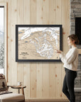 Woman looking at a framed ski trail map of Solitude mountain in a cozy living room.