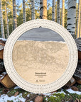 Arctic White Steamboat Colorado ski map cribbage board displayed outdoors among snowy aspen trees.