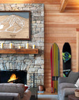 Large format, framed wooden ski map of Terry Peak ski resort above a stone fireplace in a ski cabin.