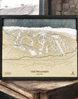Framed topographic map of Vail Mountain, Colorado on a wooden surface.