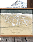 Wooden framed topographic map of Vail Mountain, Colorado with a mountainous landscape in the background.