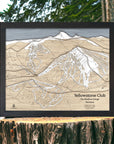 Framed large format wooden map of Yellowstone Club Ski Slopes on a wooden stump with a natural background. Torched Peaks authentic map, designed by Founder Shawn Orecchio.