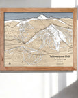 Framed three dimensional ski trail map of Yellowstone Club on a white wall in a modern ski chalet.