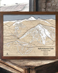 Handcrafted wooden ski map of Yellowstone Club on a rustic wooden surface in a ski cabin.