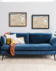 artwork of Yellowstone Club Ski Resort on a white wall above a blue sofa in a modern ski house.