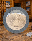 Heavenly Mountain wooden cribbage board displayed in a rustic ski cabin with playing cards, cribbage pegs, and mountain lodge décor.