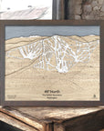 Wooden map of 49° North Ski Resort in Washington on a rustic wooden surface inside a ski cabin. 