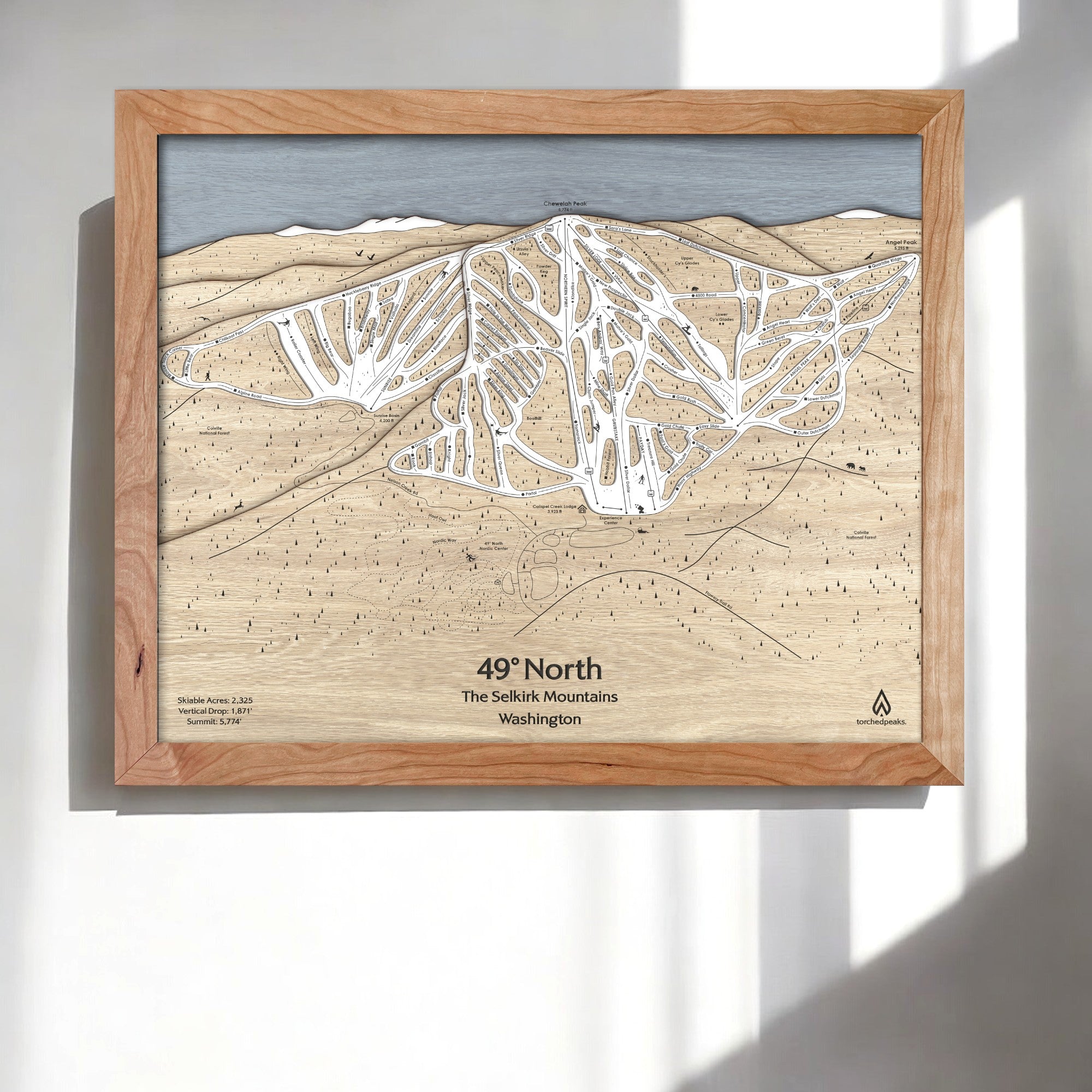 Wooden ski trail map of 49° North Ski Resort a white wall in a modern ski chalet.