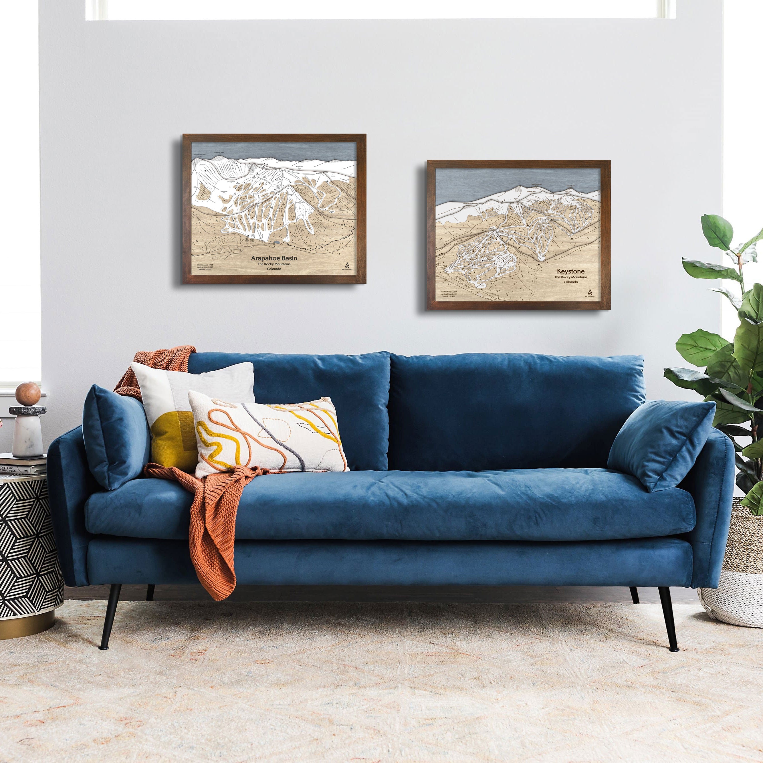 Blue sofa in a living room with framed ski resort artwork on the wall