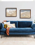 Blue sofa in a living room with framed ski resort artwork on the wall