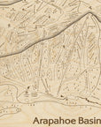 Close-up of the Arapahoe Basin wooden ski trail map showing engraved runs, chairlifts, mountain landmarks, and dimensional terrain.