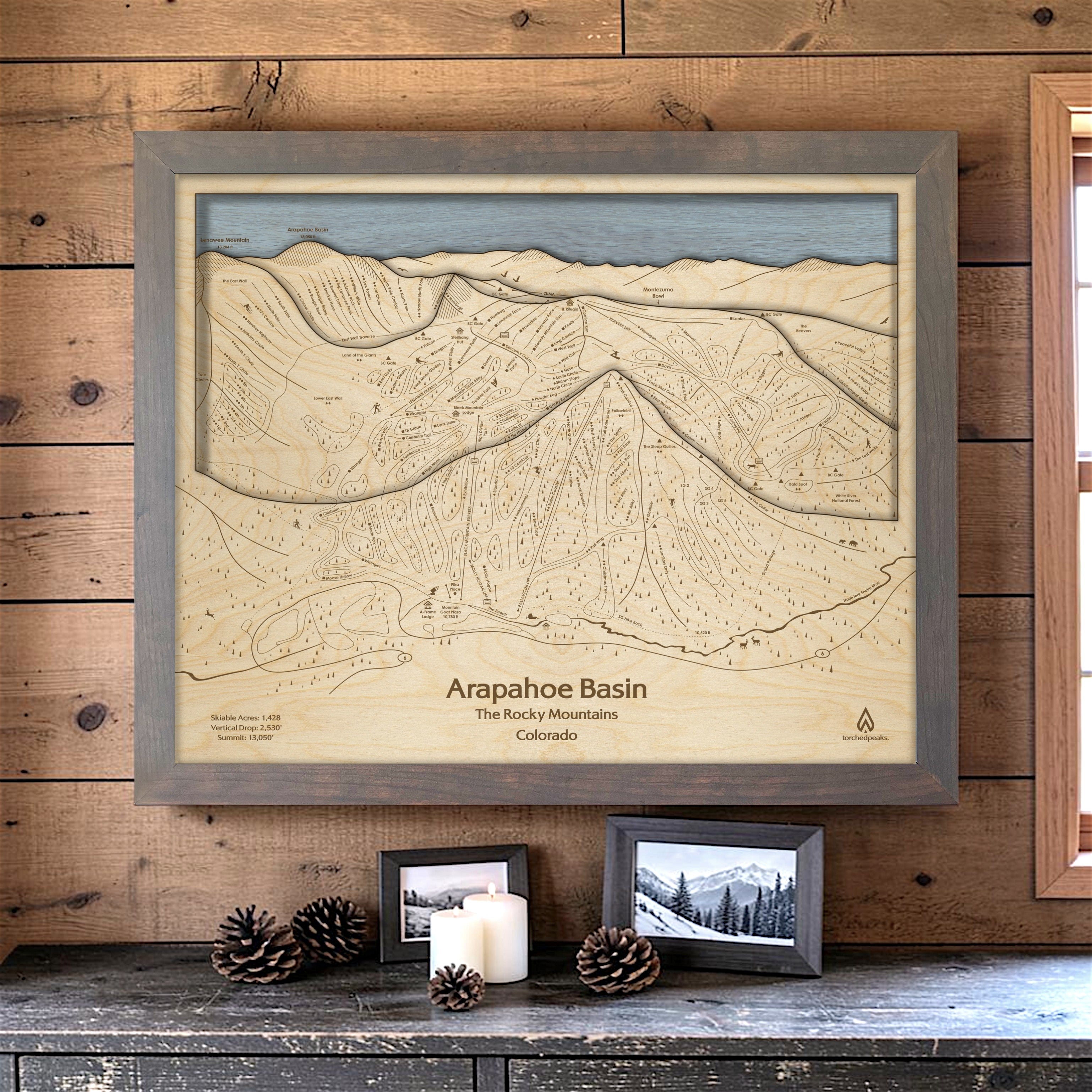 Storm Grey Arapahoe Basin ski map wall art mounted on a wood-paneled wall in a cozy ski cabin.