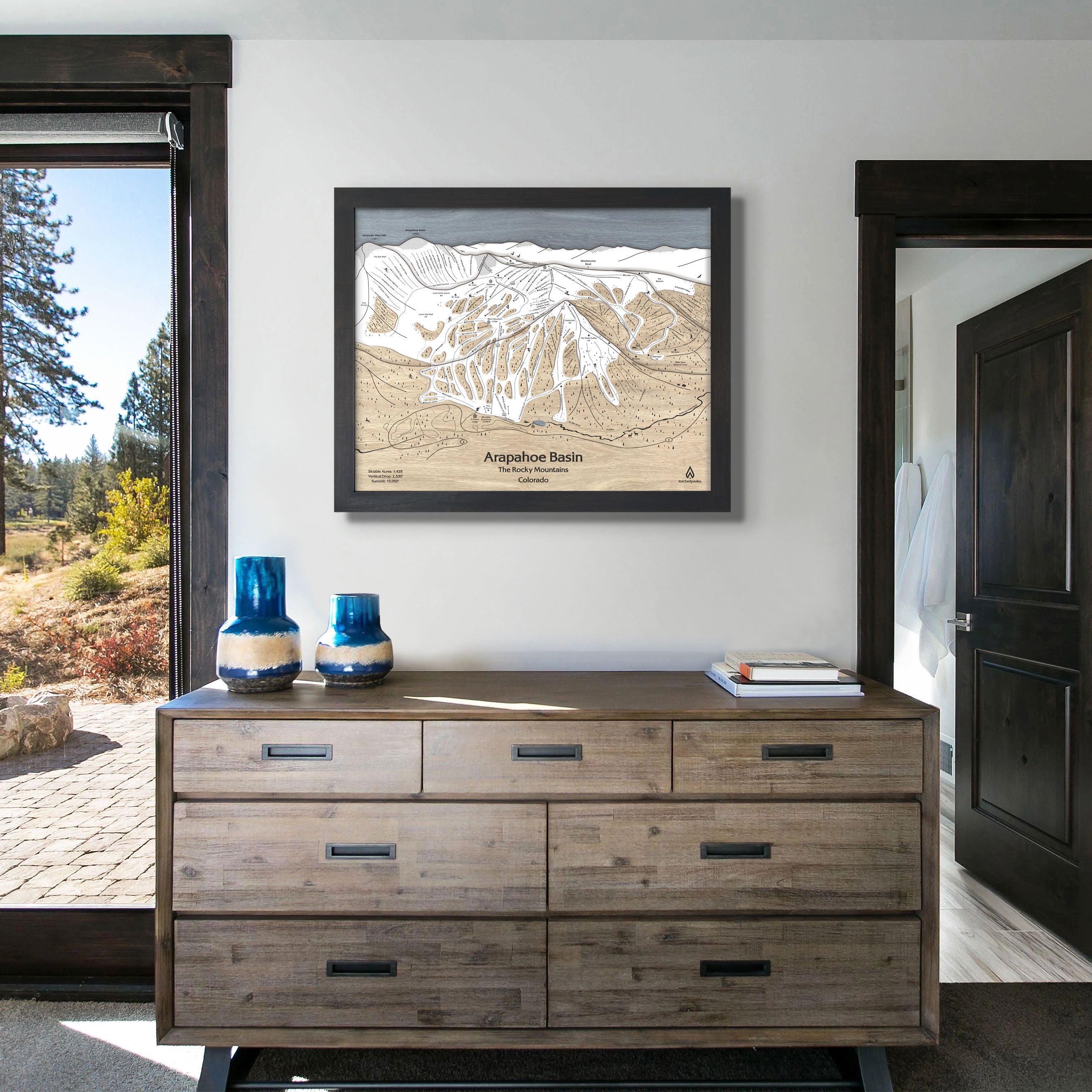 Arapahoe Basin Ski Resort map hanging on a wall above a dresser. 