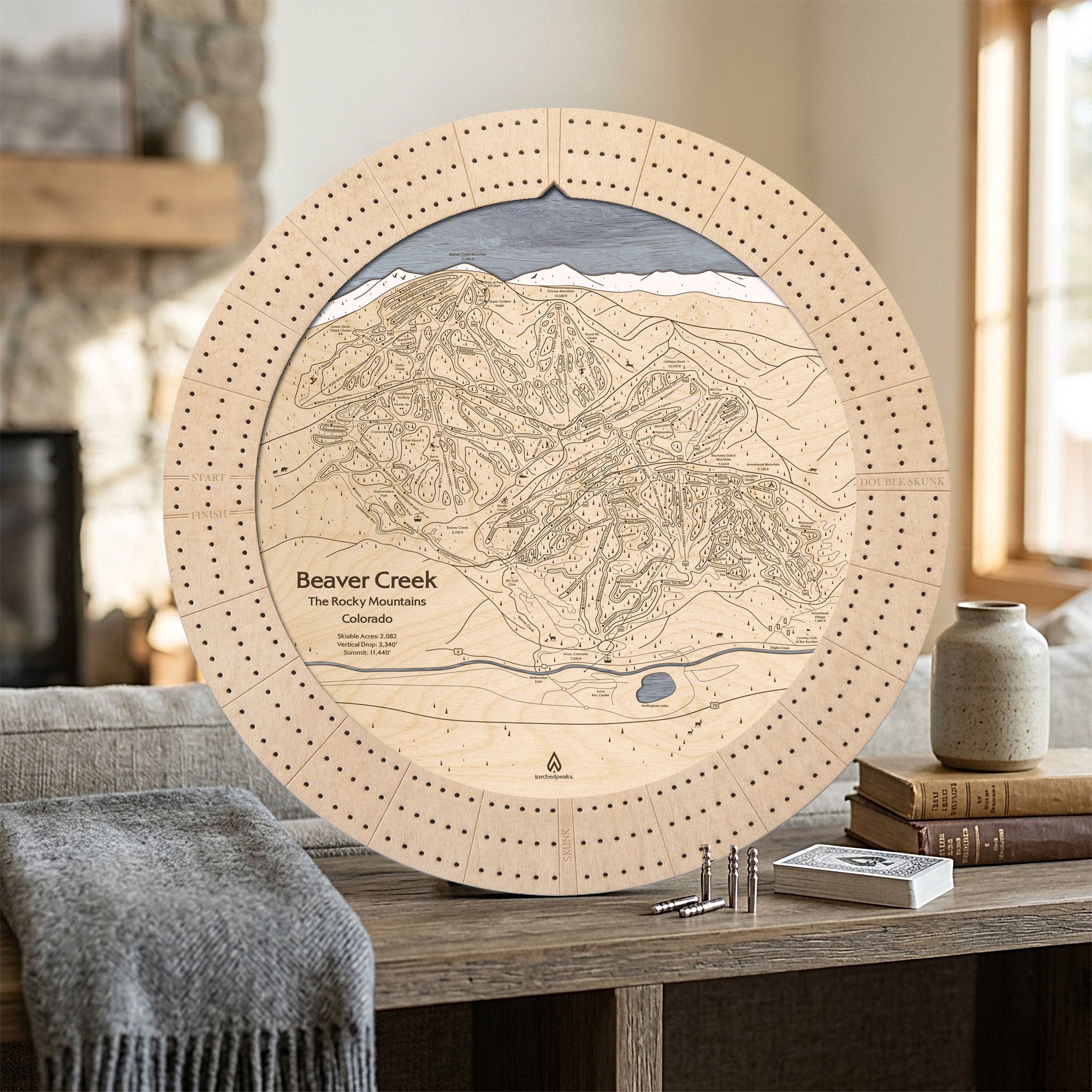 Birch Beaver Creek wooden ski map cribbage board displayed in a cozy mountain home as a unique gift for skiers.