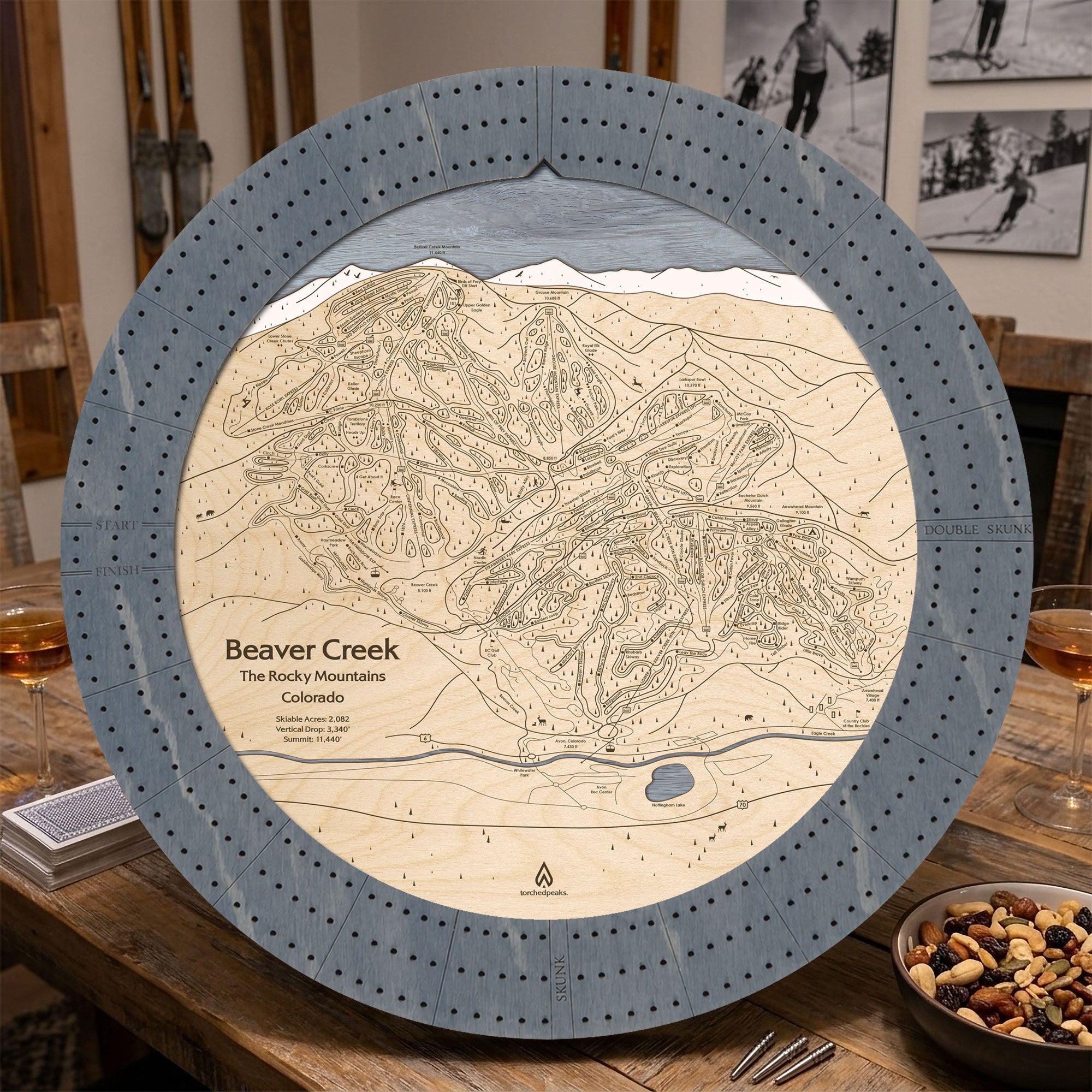 Graphite Grey Beaver Creek ski trail map cribbage board staged with playing cards and après-ski snacks.