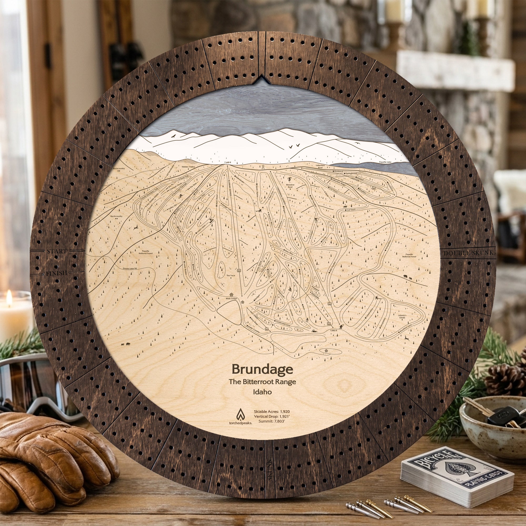 Rustic Mocha Brundage Mountain ski map cribbage board staged with cards and snacks, a unique gift for skiers.