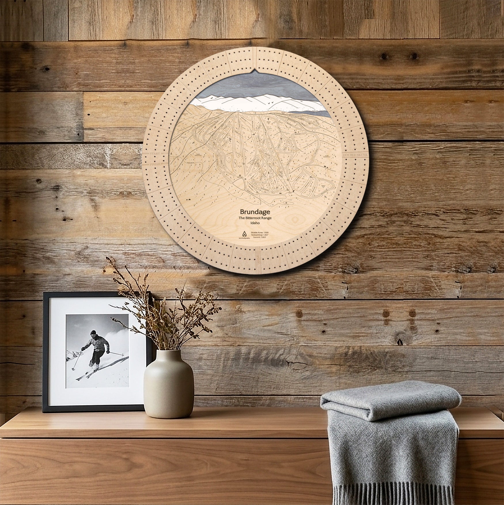 Brundage Mountain wooden ski map cribbage board displayed on a reclaimed-wood wall above a console as functional wall art.