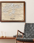 Framed wooden map of Deer Valley Ski Resort on a wall above a chair in a ski cabin.