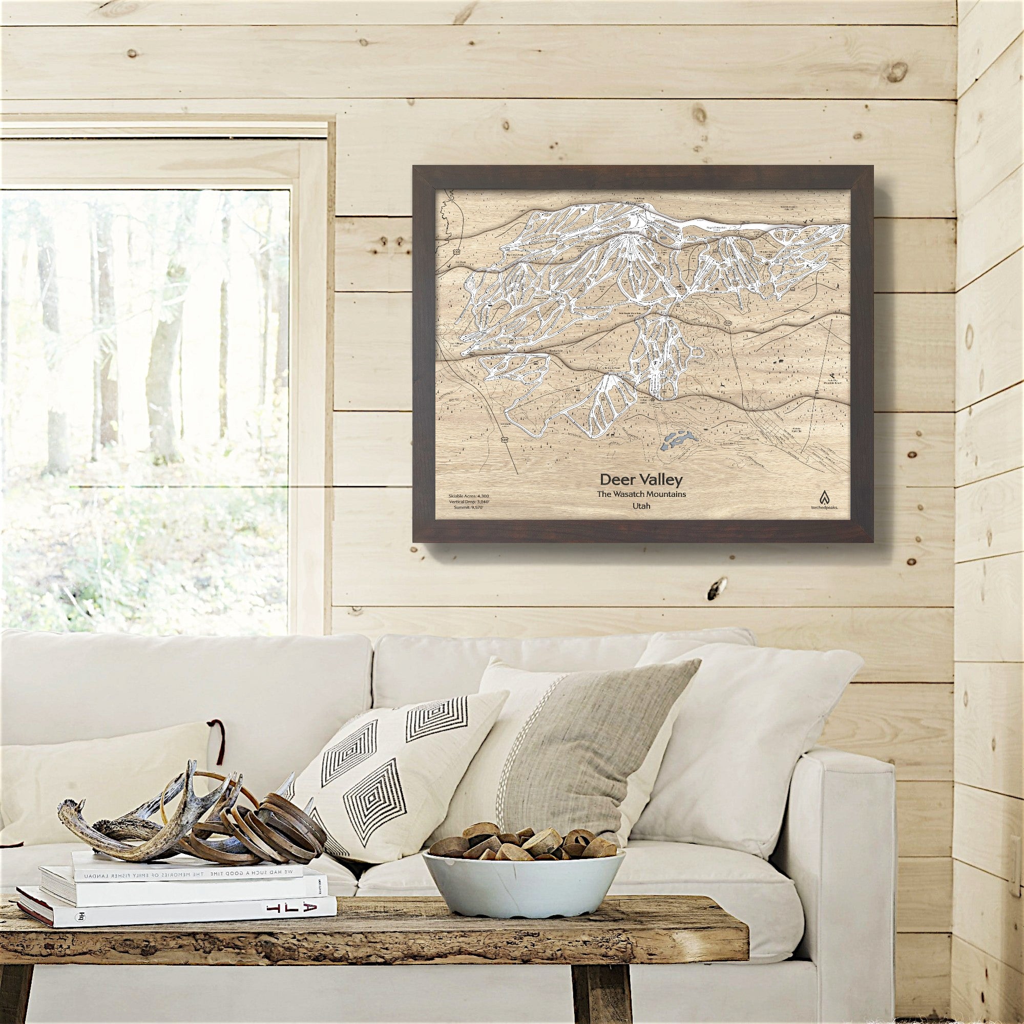 Framed 3D artwork of Deer Valley Ski Slopes on a wooden wall above a sofa.