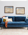 Blue sofa in a living room with framed skiing artworks on the wall.