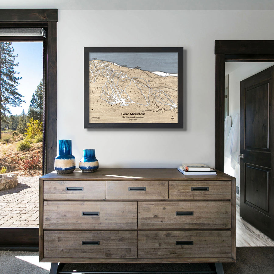 Wooden framed skiing map of Gore Mountain in a bedroom. 