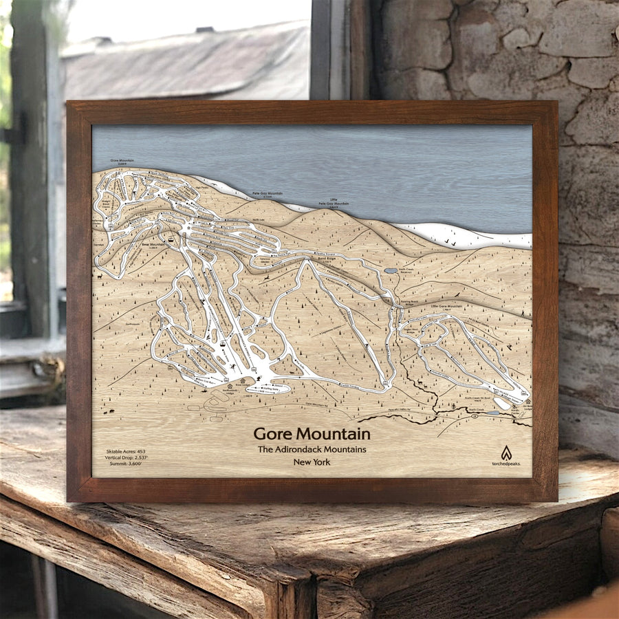 Wooden framed map of Gore Mountain, Adirondack Mountains, New York on a rustic surface inside a ski cabin. 