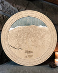 Killington wooden ski map cribbage board in Birch beside a stone fireplace with candles and pinecones.