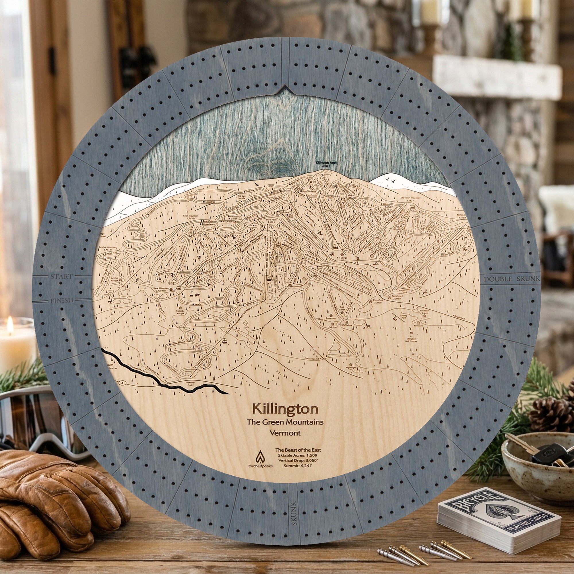 Killington ski trail map cribbage board in Graphite Grey styled on a rustic cabin table.