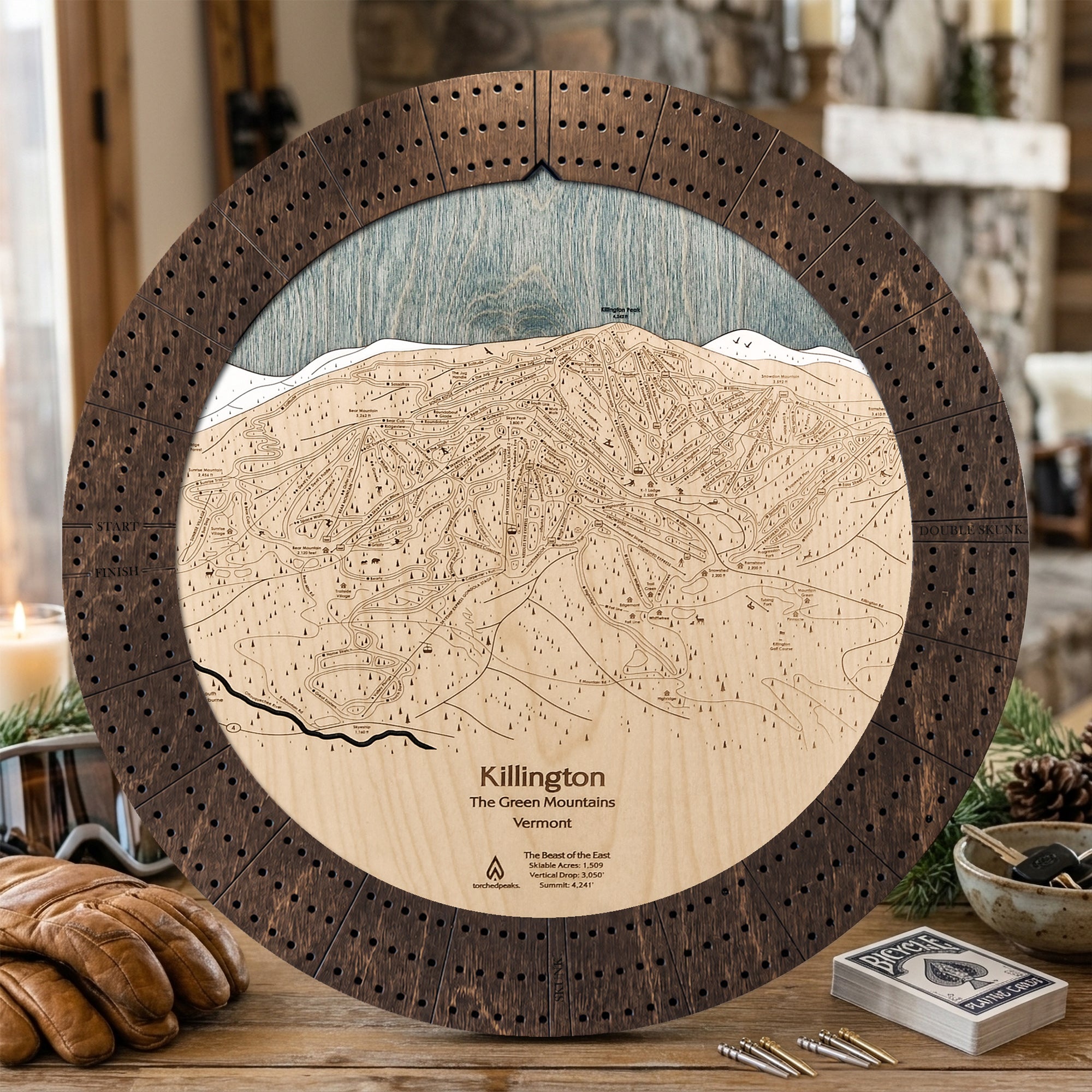 Killington ski map cribbage board in Rustic Mocha styled on a cabin table with playing cards.
