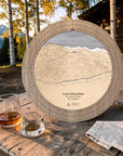 Weathered Timber Loon Mountain ski map cribbage board displayed on an outdoor cabin table beside whiskey glasses.