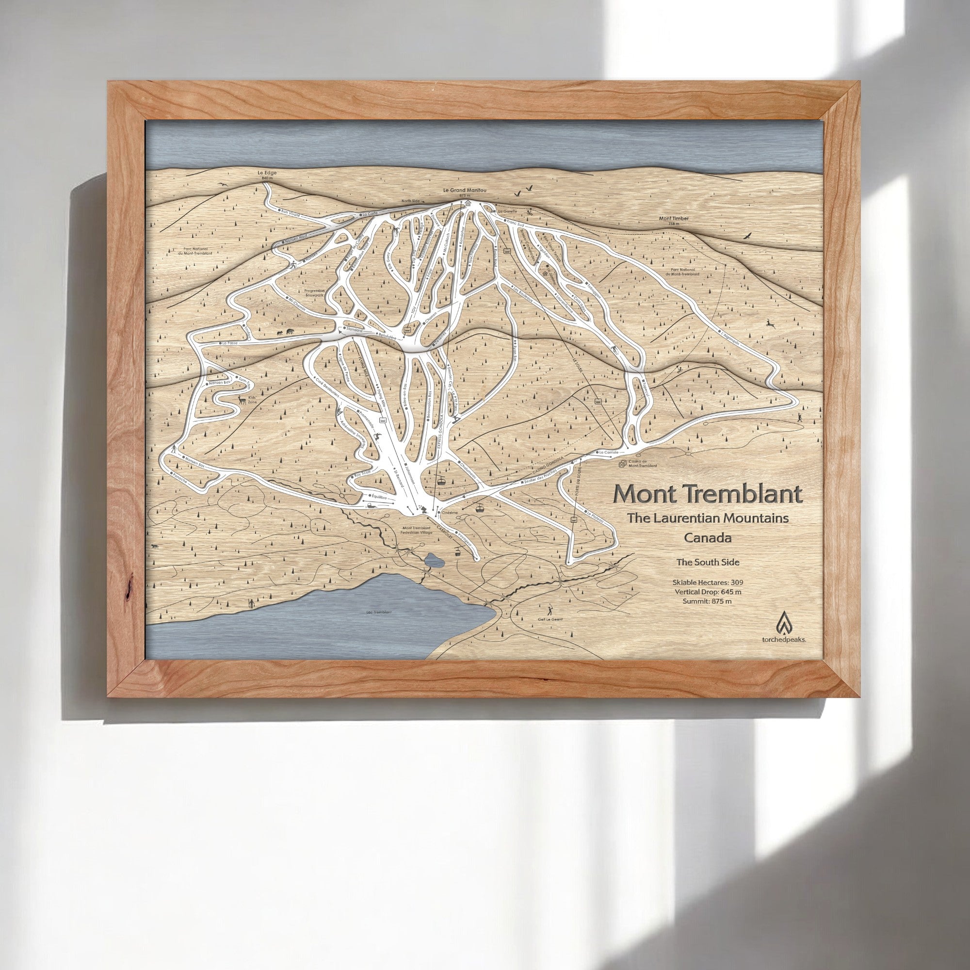 Wooden framed ski trail map of Mont Tremblant, Laurentian Mountains, Canada on a white wall in a modern ski cabin.