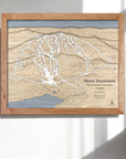 Wooden framed ski trail map of Mont Tremblant, Laurentian Mountains, Canada on a white wall in a modern ski cabin.