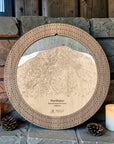 Northstar cribbage board in Weathered Timber beside a stone fireplace with candles and pinecones.
