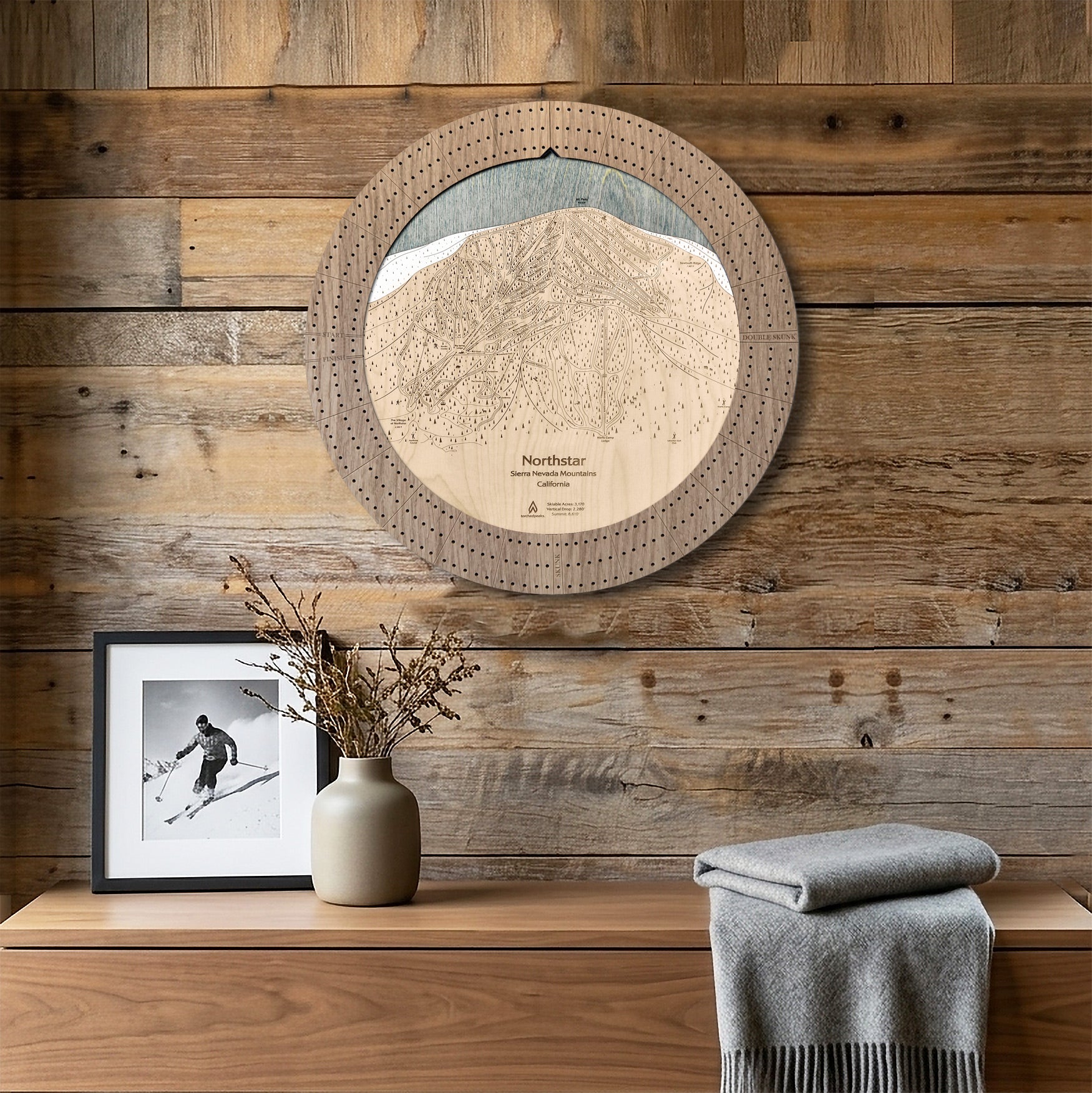 Northstar ski map cribbage board displayed as round wall art above a rustic wood console.