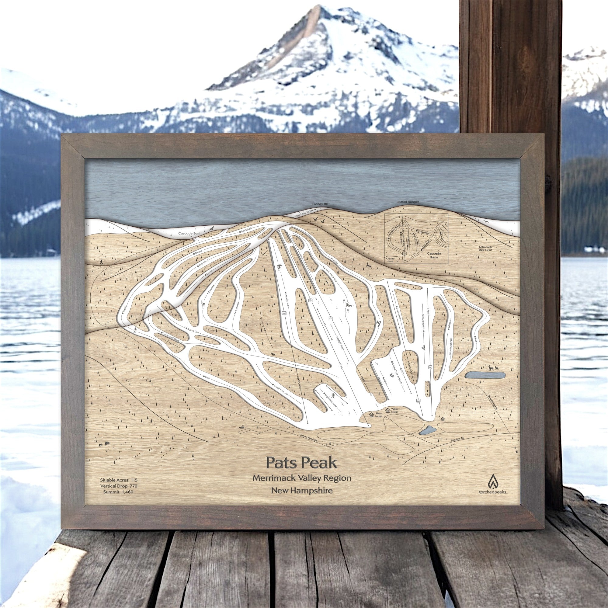 Wooden framed ski trail map of Pats Peak with mountain and lake background