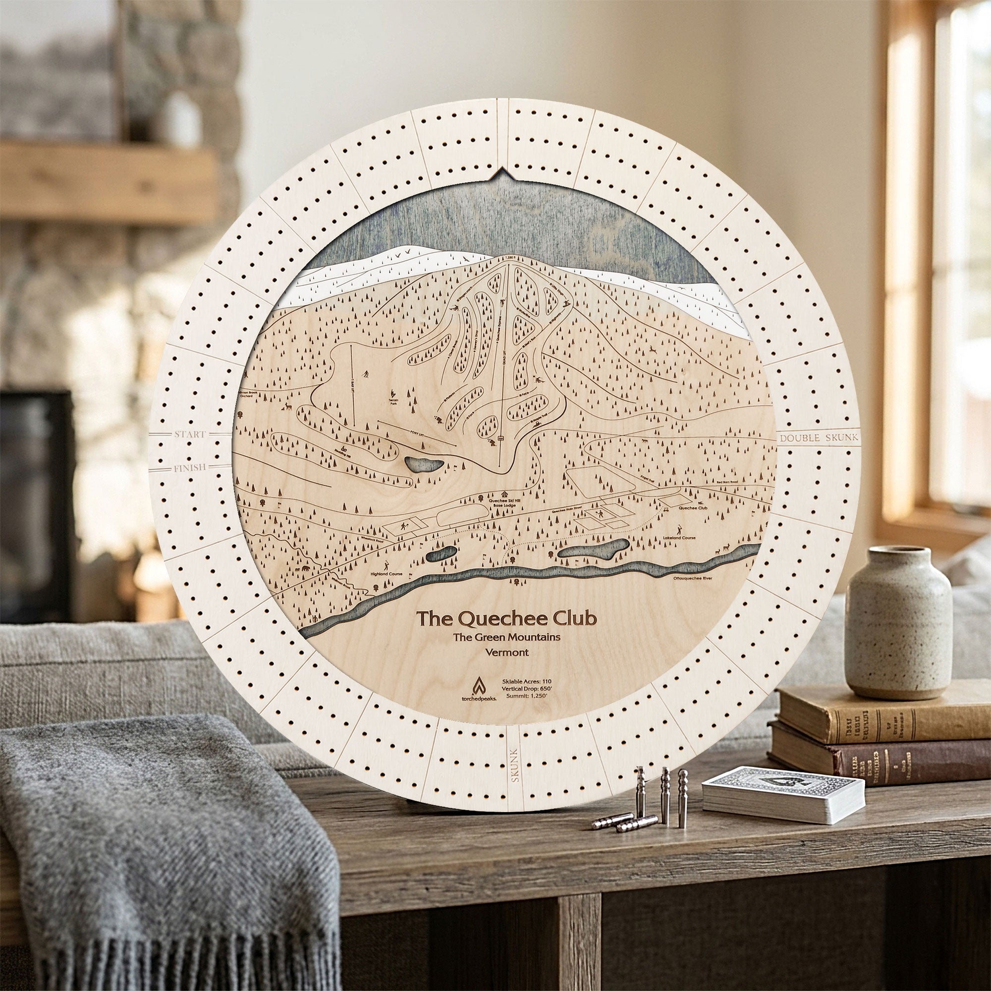 The Quechee Club Vermont ski map cribbage board in Arctic White displayed in a bright mountain home.