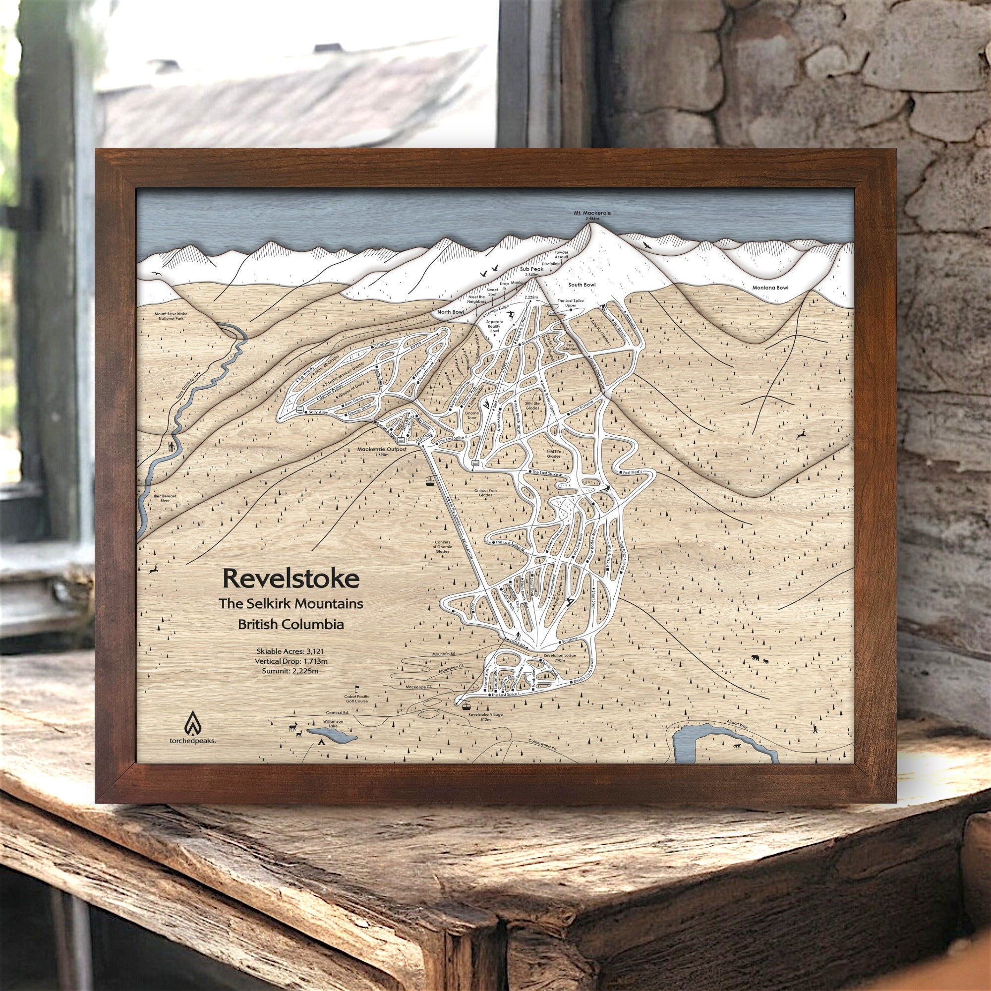 Framed ski map of Revelstoke Mountain, British Columbia on a wooden surface in a rustic ski cabin.  