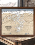 Framed ski map of Revelstoke Mountain, British Columbia on a wooden surface in a rustic ski cabin.  