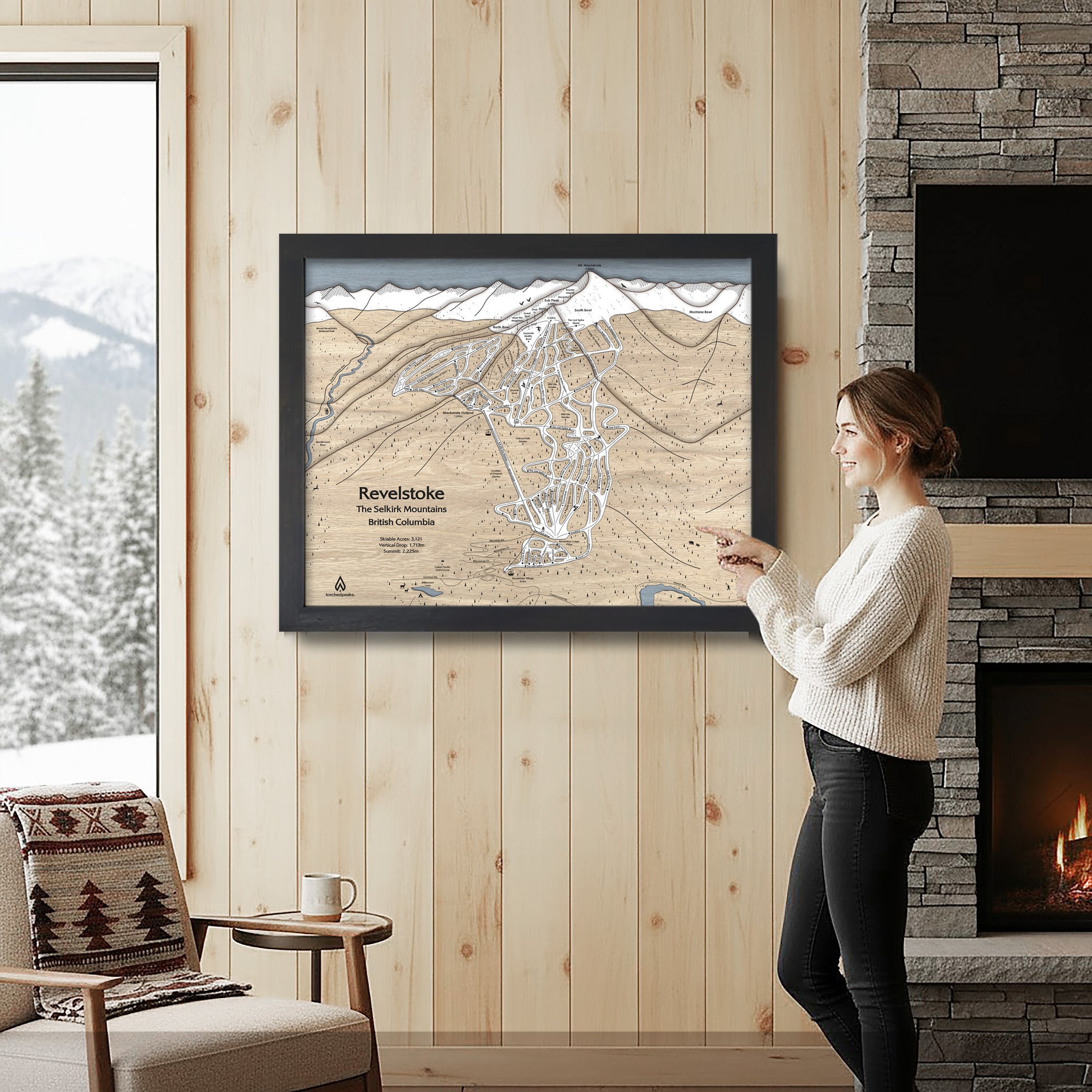 Woman looking at a framed map of Revelstoke Ski Resort set in a cozy rustic ski cabin.